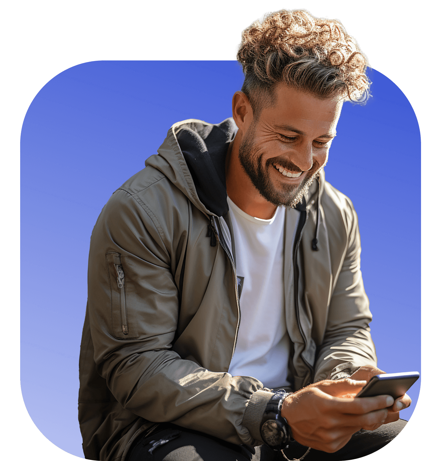 Smiling man with curly hair and a green jacket, texting on his phone after purchasing tickets